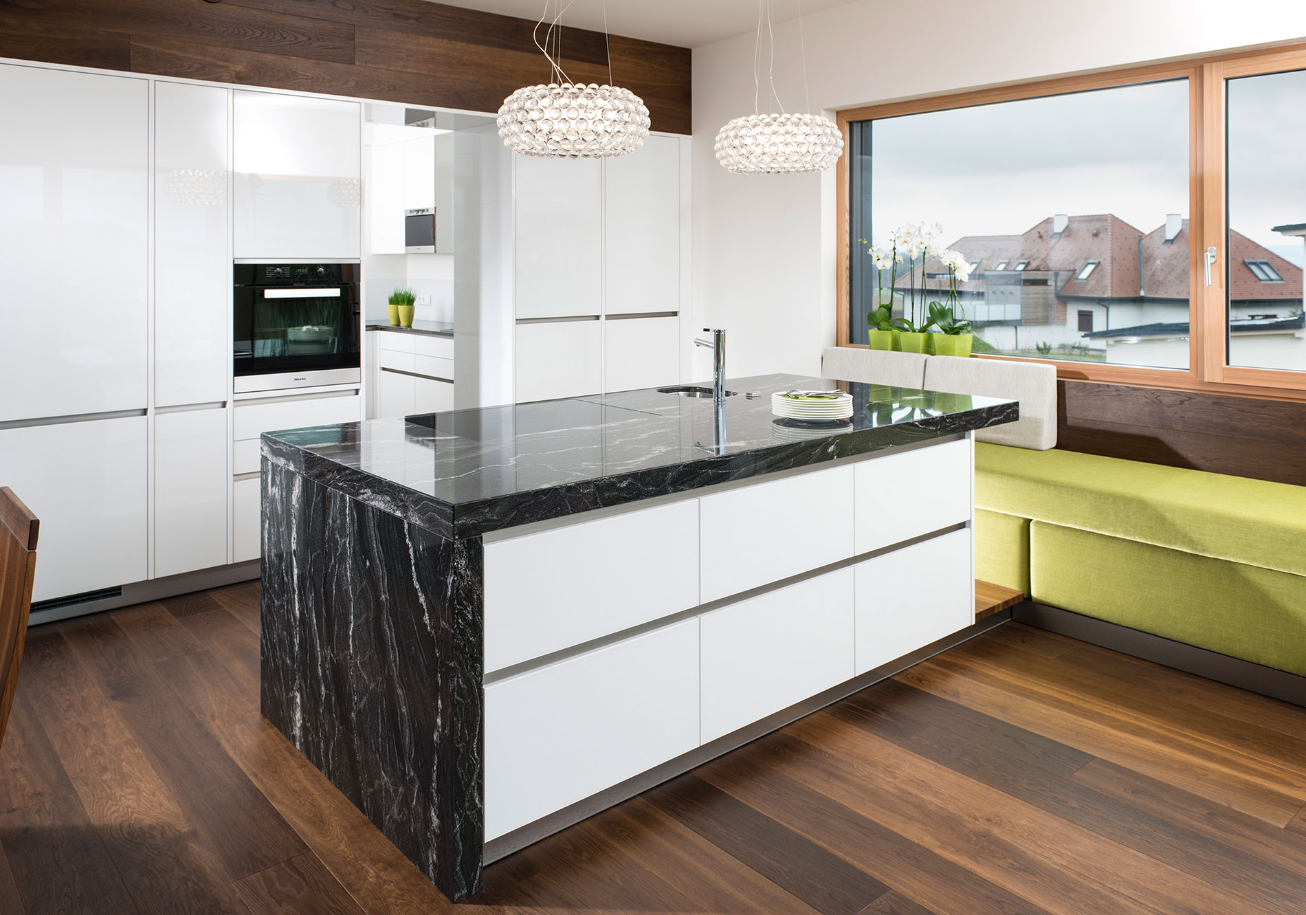 helle Küchenmöbel und dunkle Küchenarbeitsplatte aus Naturstein