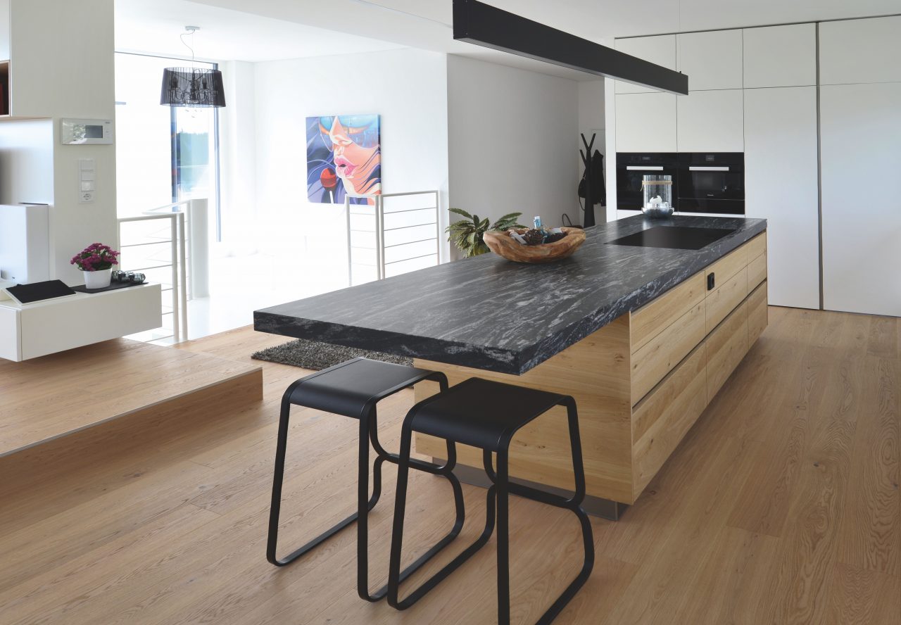 Kücheninsel mit Holzfront und schwarz-weiß marmorierter Arbeitsplatte aus Naturstein