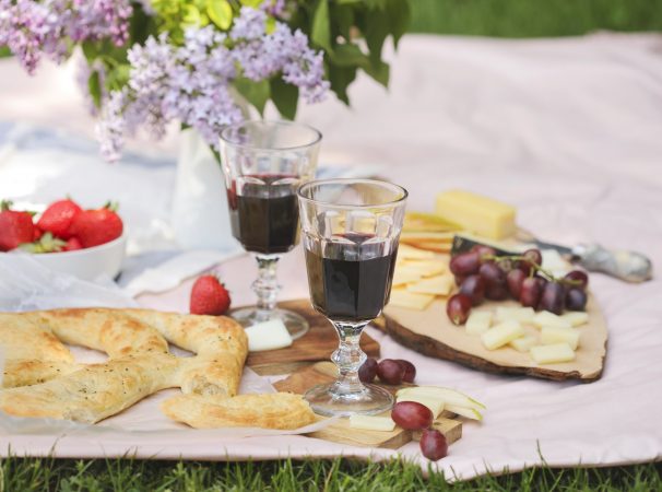 Picknick im Park mit Käse, Brot, Wein und Obst.