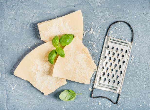 Scheiben von Parmesan Käse auf einer hellgrauen Steinplatte